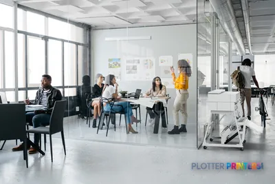 HP DesignJet XT950 36-in printer in a modern office workspace with team members reviewing large-format prints on wall