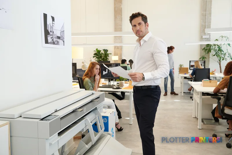 Man holding large format print from HP DesignJet T950 36-in printer in modern office setting