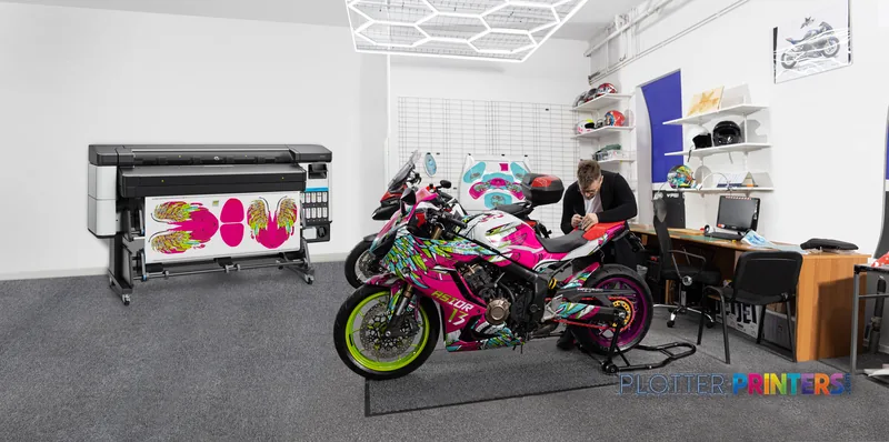HP Latex 630 W Print and Cut Plus Solution lifestyle image showing the black printer displaying colorful graphics in a creat…