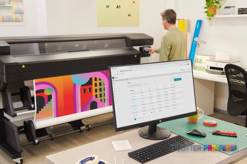 HP Latex 630 Printer lifestyle image showing the black large-format printer in an office setting with colorful output