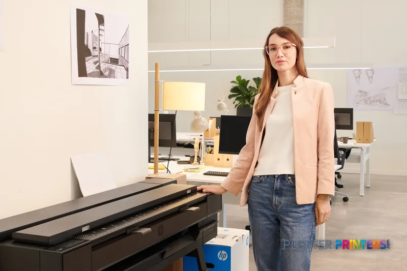 Woman standing next to HP DesignJet T850 36-in printer in modern office lifestyle setting