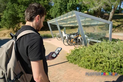 Man viewing HP Latex FS60 Printer lifestyle image on mobile device in outdoor park setting