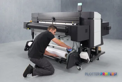 HP Latex R530 Printer lifestyle image showing operator loading media into the printer