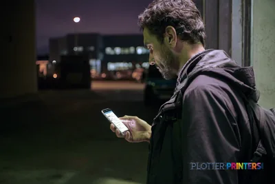 Man holding smartphone outdoors at night in HP Latex 2700 W lifestyle image