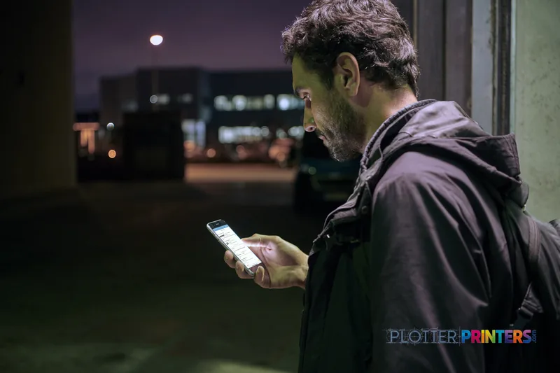 Man holding smartphone outdoors at night in HP Latex 2700 W lifestyle image