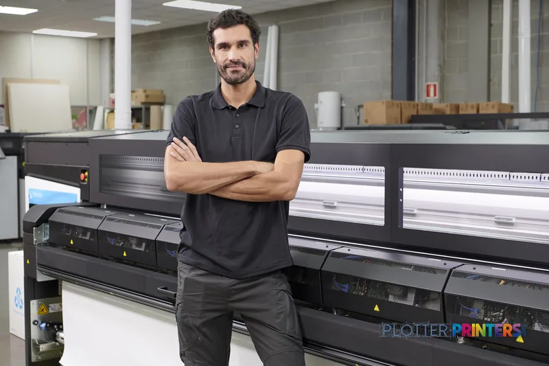 Man posing in front of HP Latex 2700 W Printer in a print shop workspace
