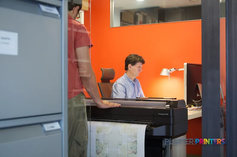 HP Designjet T520 large format printer lifestyle image showing person using the printer in an office setting