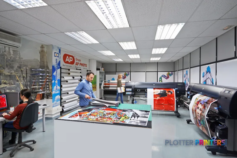 HP Designjet Z6800 lifestyle image showing the black printer in a professional print shop with staff handling large format p…