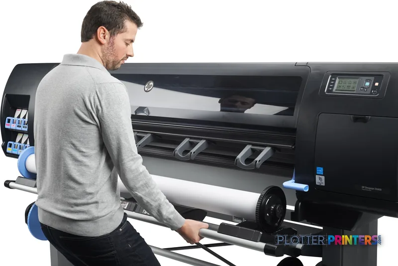 Man operating HP Designjet Z6800 large format printer, loading roll media into black thermal inkjet printer