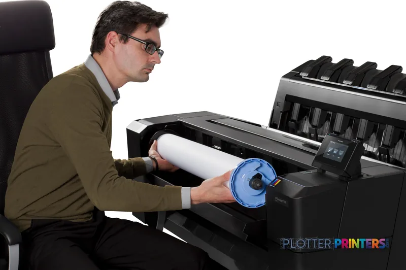 Man loading a roll of paper into an HP Designjet T930 large format printer in a lifestyle setting