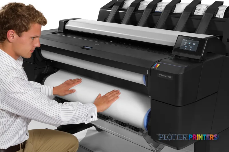 Man loading large-format paper into HP Designjet T2530 printer in office setting