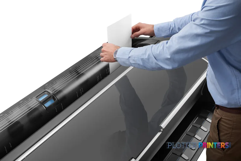 HP Designjet Z5600 44-in PostScript lifestyle image showing a person loading paper into the printer