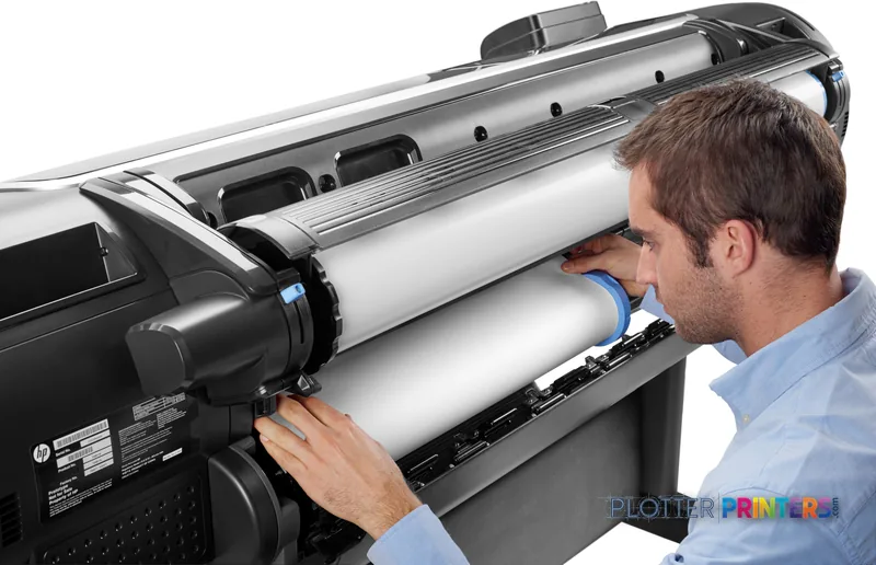 HP Designjet Z5600 44-in PostScript printer lifestyle image showing a man loading paper into the wide-format printer