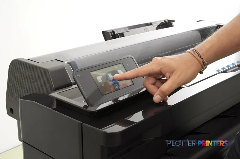 HP DesignJet T120 lifestyle image showing a user's hand operating the touchscreen display on the black printer