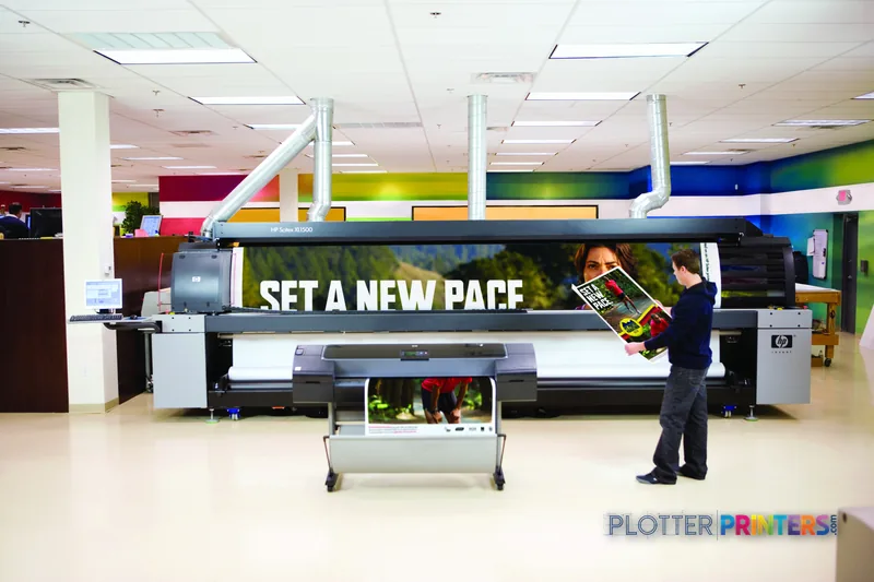 HP DesignJet Z2100 24 in photo printer lifestyle image showing operator working with large-format print output in profession…
