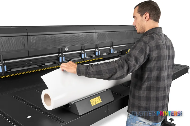 Man loading a roll of white media into the HP Latex R2000 Plus Printer large-format printer