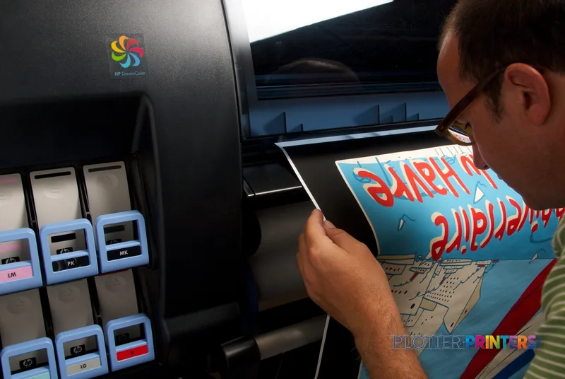 HP DesignJet Z6200 lifestyle image showing a person holding a large-format color print with vibrant red and blue graphics