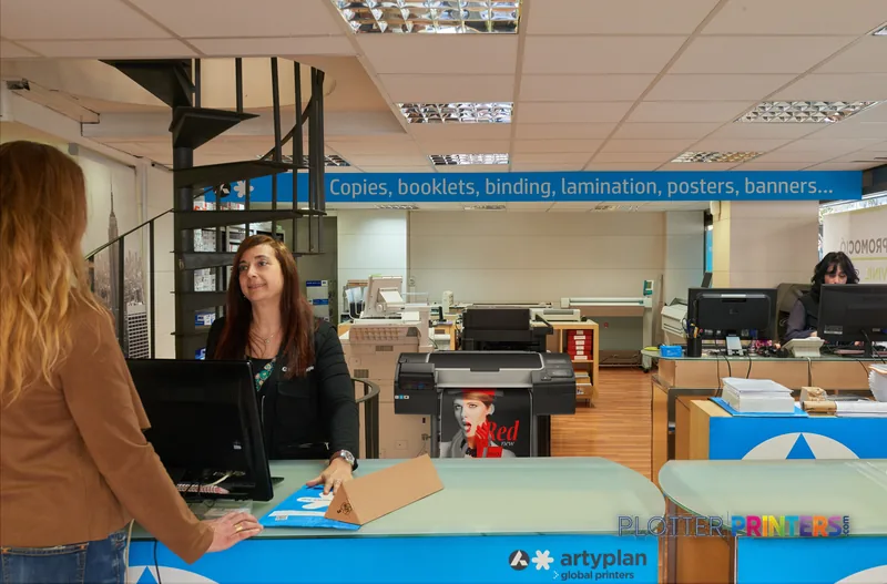 HP Designjet Z6200 60-in Photo Printer in a print shop lifestyle setting with staff and finished prints