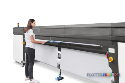 HP Stitch S1000 126-in Printer lifestyle image showing operator loading media into the black large-format printer