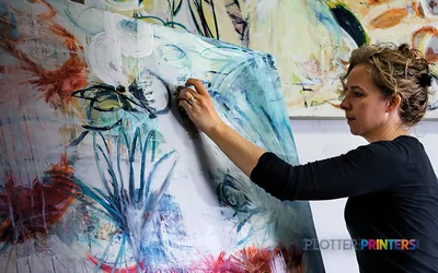 Artist reviewing a large-format color print from the Epson SureColor SC-P9500 printer displayed on a studio wall