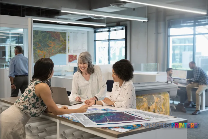 HP DesignJet Z6dr 44-in PostScript Printer lifestyle image showing professionals reviewing large-format prints in an office