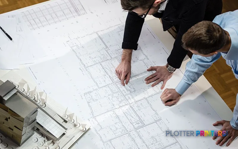 Epson SureColor SC-T5405 printer in use, showing two people reviewing large-format architectural blueprints printed from the…