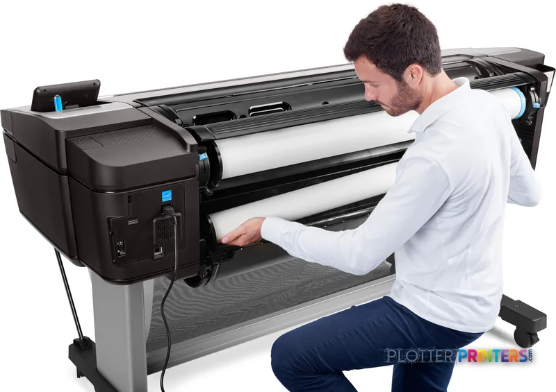 HP DesignJet T1700dr 44-in PostScript Printer lifestyle image showing a man loading paper into the black printer