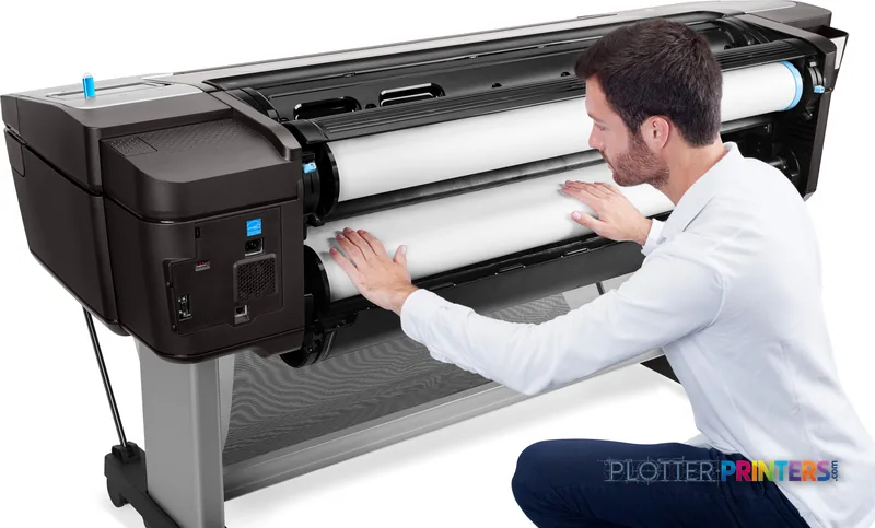 HP DesignJet T1700dr 44-in PostScript Printer lifestyle image showing a man loading large-format paper into the black printer