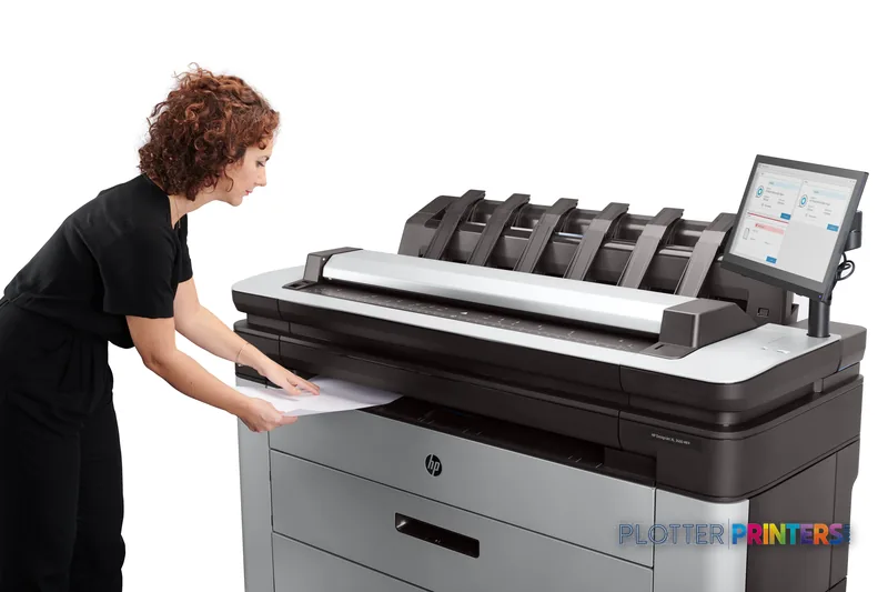 HP DesignJet XL 3600dr 36-in Multifunction Printer lifestyle image showing a person retrieving a large-format print from the…