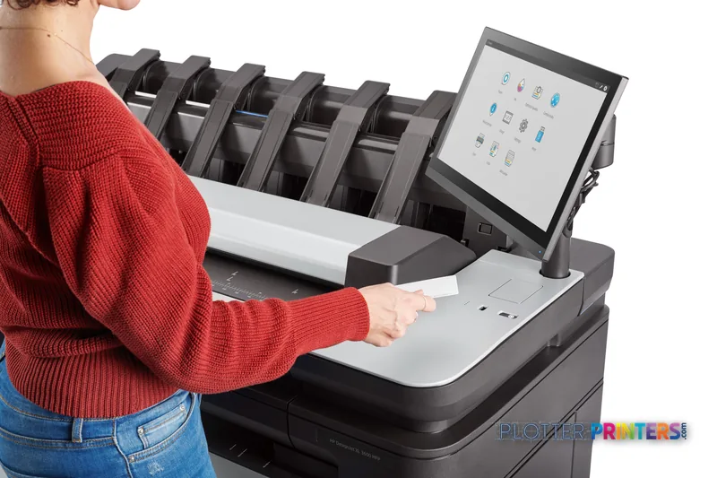 HP DesignJet XL 3600dr 36-in Multifunction Printer lifestyle image showing a user retrieving printed output from the device