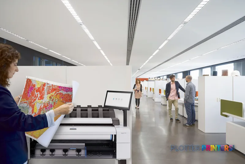 HP DesignJet T2600 36-in PostScript Multifunction Printer in a professional office environment with a user holding colorful…