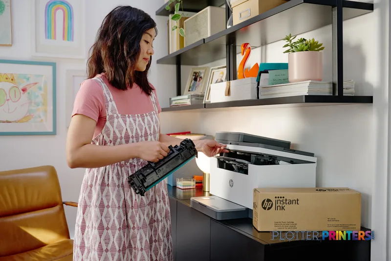 Woman replacing ink cartridge in white HP DesignJet T2600 36-in printer in home office setting
