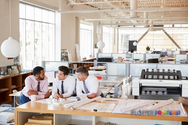 HP DesignJet T1600dr 36-in PostScript Printer lifestyle image showing the white printer in a bright architectural office wit…