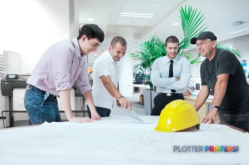 HP DesignJet T730 36-in Printer lifestyle image showing team reviewing large-format prints in office