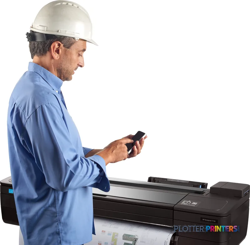 Construction worker in hard hat using smartphone next to HP DesignJet T730 36-in Printer in lifestyle setting