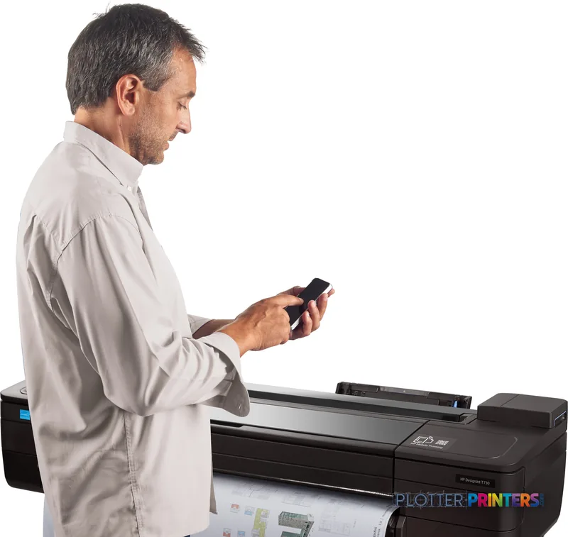 Man in light shirt holding smartphone while operating HP DesignJet T730 36-in Printer in lifestyle setting