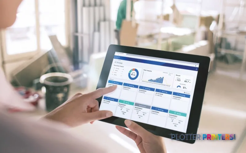 Person holding a tablet displaying a dashboard interface in an office environment