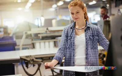 Woman holding printed output in front of Epson SureColor SC-F10000H large format printer in production facility